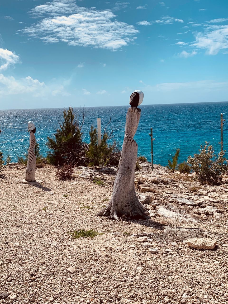 WOODEN POST ON BEACH AGAINST SKY