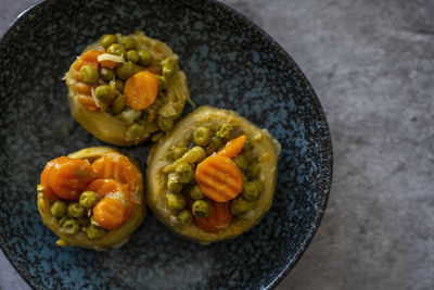 Cooked spiny artichoke with olive oil and carrots and peas,top view ,selective focos