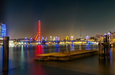 Illuminated golden jubilee bridge over thames river at night