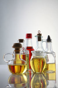 Palm oil, sesame seed oil, olive oil, grape seed oil and corn oil in glass bottle over white 