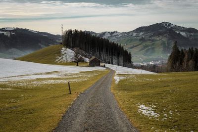 Road by mountain against sky