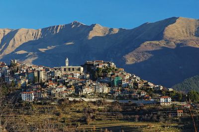 Townscape by mountains against clear sky