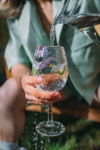 Midsection of woman holding wineglass