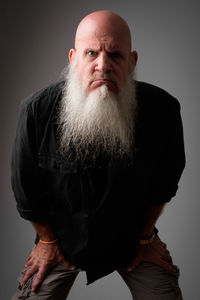 Portrait of man standing against gray background