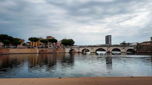 Arch bridge over river against sky