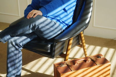 Low section of man sitting on sofa at home