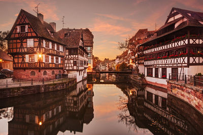 Reflection of buildings in water at sunset