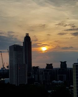 Modern buildings against sky during sunset