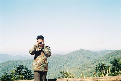 Rear view of man standing against clear sky