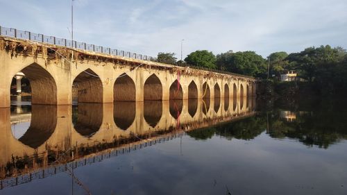 Arch bridge over river against sky