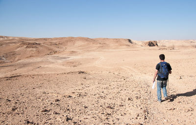 Rear view of man on arid landscape