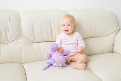 Cute baby girl lying on sofa at home