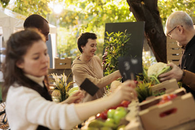 Portrait of smiling friends sitting on table