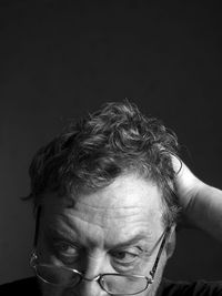 Close-up portrait of mid adult man against black background