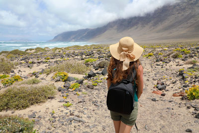 Rear view of woman standing at beach 