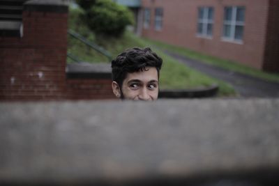 Boy looking away against wall