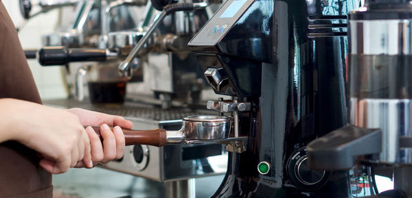Midsection of man having coffee at cafe