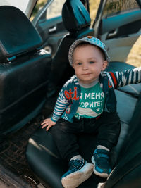 Portrait of cute boy sitting in car
