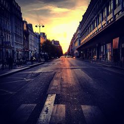 City street against sky at sunset