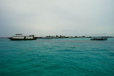 Boats sailing in calm sea against sky