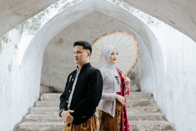 Rear view of man and woman walking on staircase