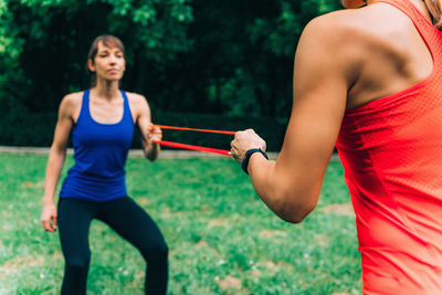 Female athletes exercising with resistance bands at park