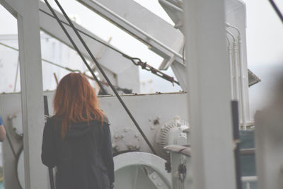 Rear view of woman standing in boat