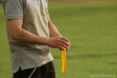 Midsection of man holding golf course