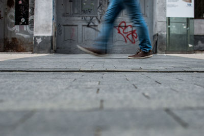 Blurred motion of man walking on footpath