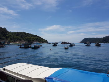 Boats in calm blue sea against sky