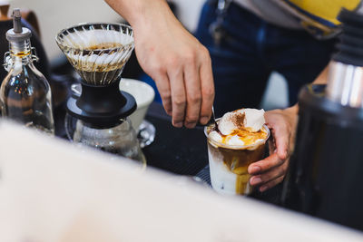 Barista making iced latte coffee by pouring espresso shot