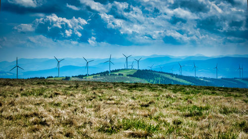 Wind turbines on land against sky