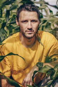Portrait of man sitting amidst plants