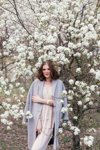 Beautiful girl in a dress walking in a blooming garden