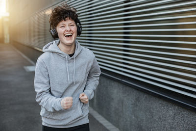 Portrait of young man standing against wall