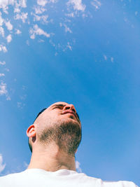 Low angle portrait of young man against blue sky
