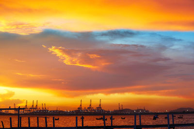 Scenic view of sea against dramatic sky during sunset