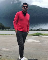 Young man wearing sunglasses standing on land