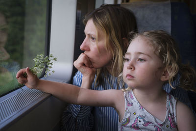 Portrait of mother and girl looking at camera