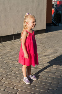 Full length of young woman walking on footpath