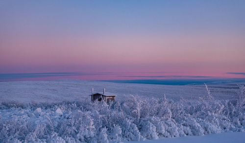 Scenic view of snowy field against sky during winter