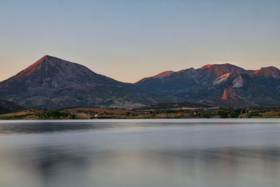 Scenic view of lake and mountains against clear sky