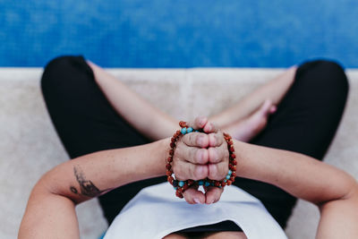 Low section of woman exercising by swimming pool