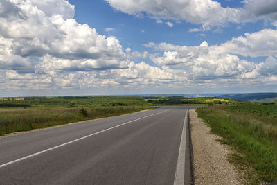 Empty road along countryside landscape