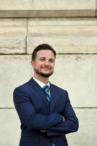 Portrait of businessman standing against wall