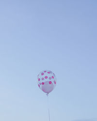 Low angle view of balloons against blue sky