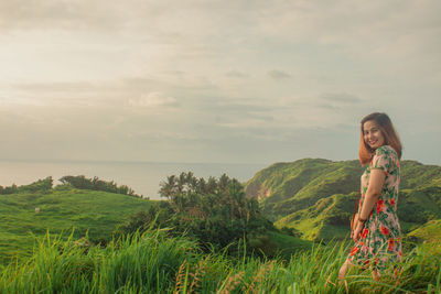 Woman standing by plants against sky