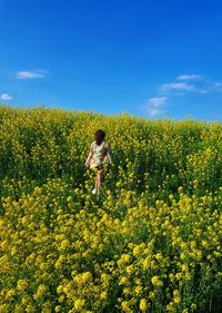 Full length of woman walking on grassy field against sky