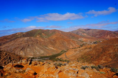 Scenic view of mountains against blue sky