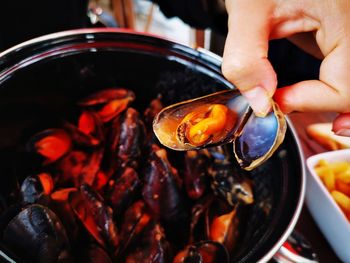 Close-up of person preparing food seashells 